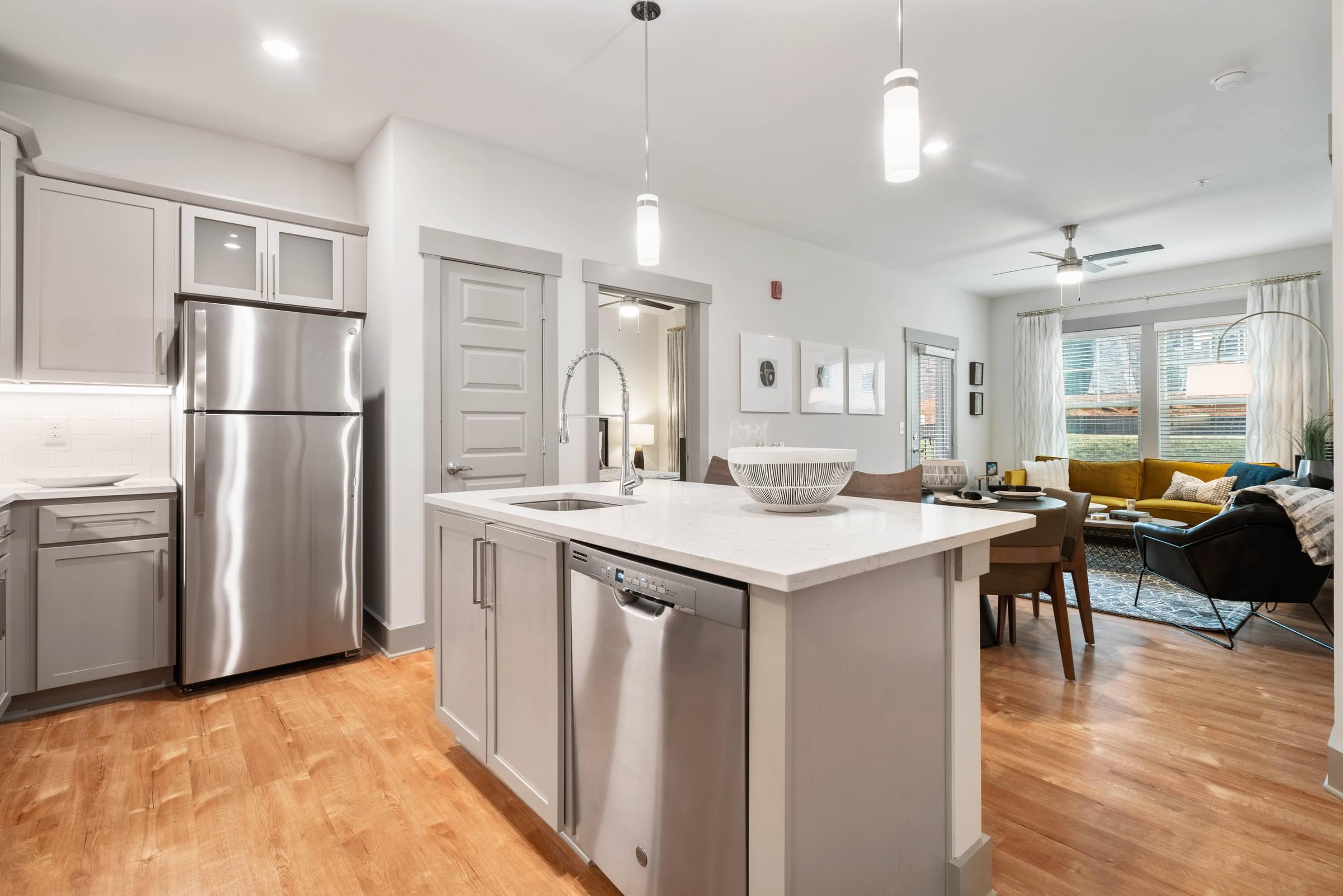 A modern kitchen with stainless steel appliances and wooden floors.