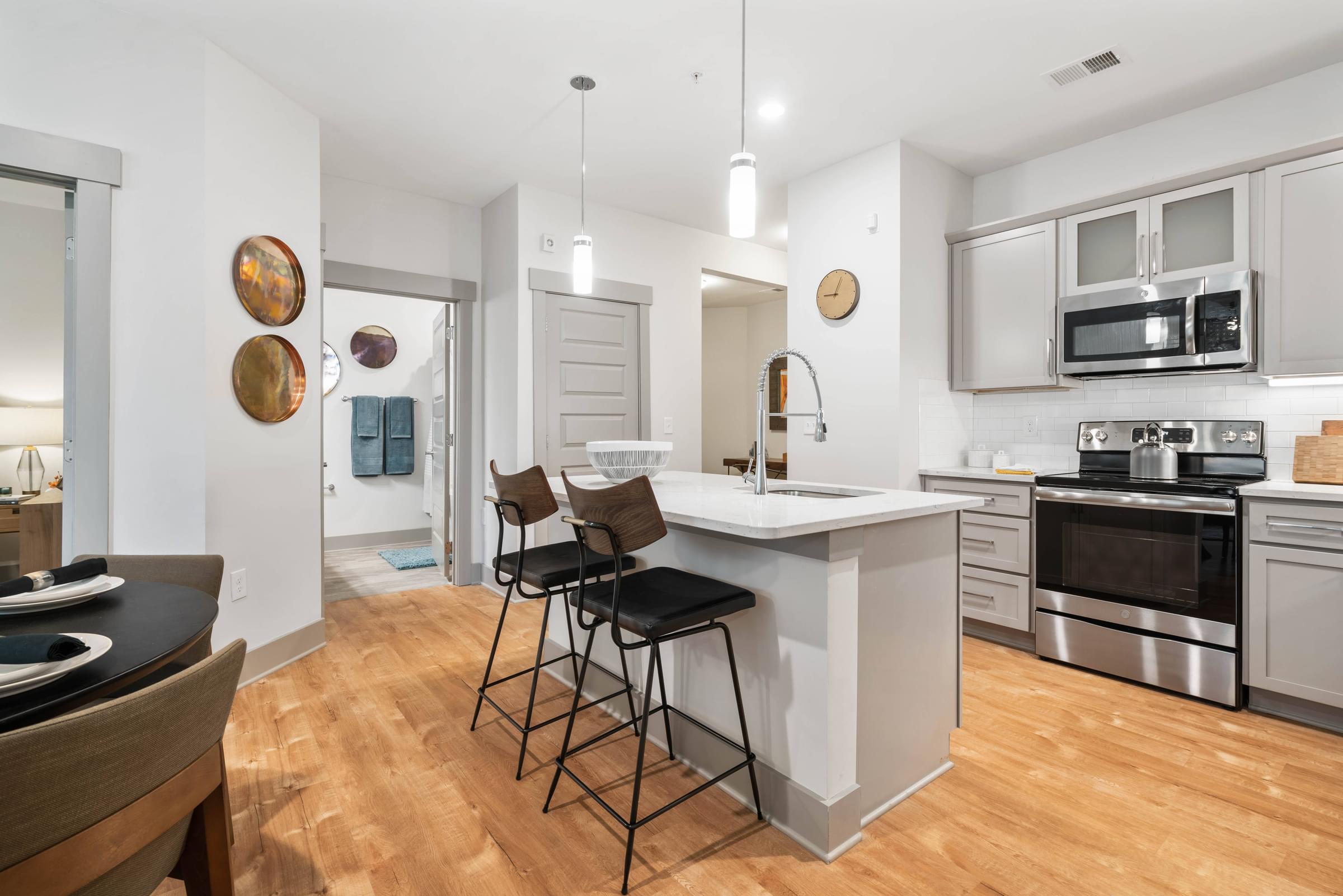 A modern kitchen with a white island and stainless steel appliances.