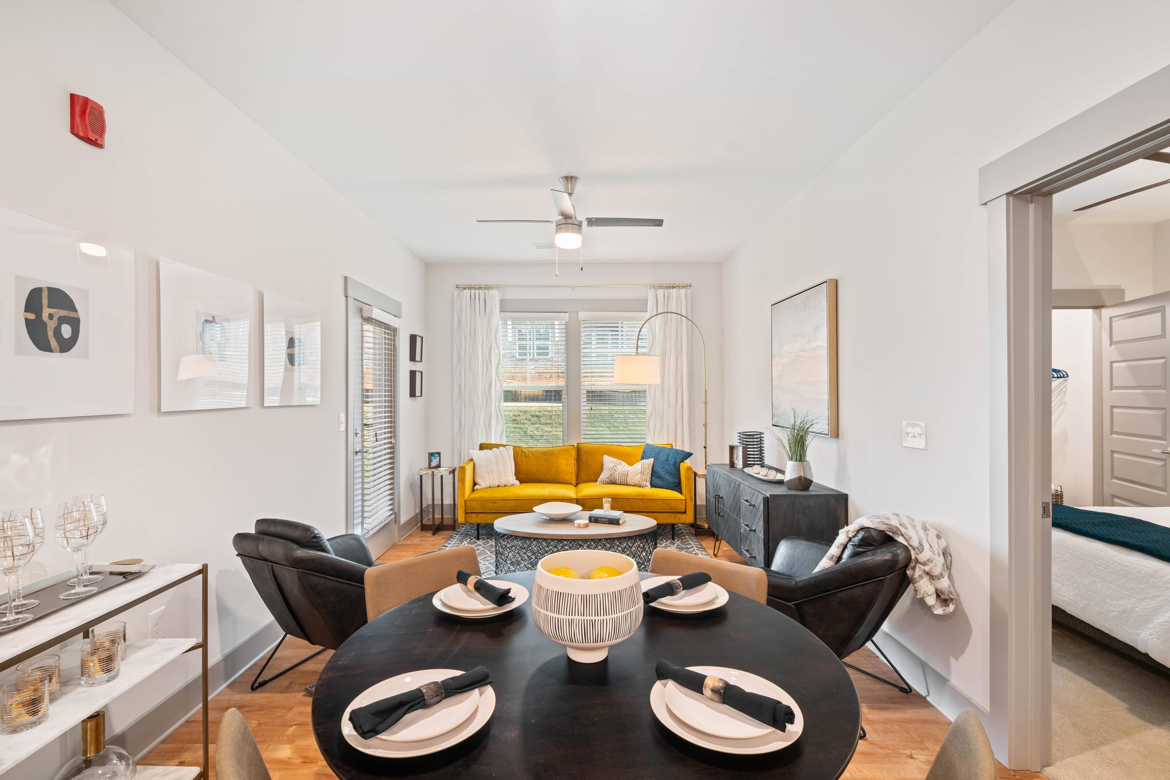 A dining room with a black table and chairs.
