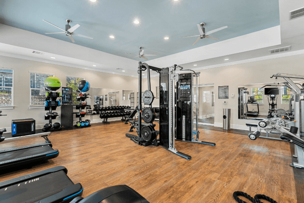 an apartment gym with weights and cardio equipment on a hard wood floor