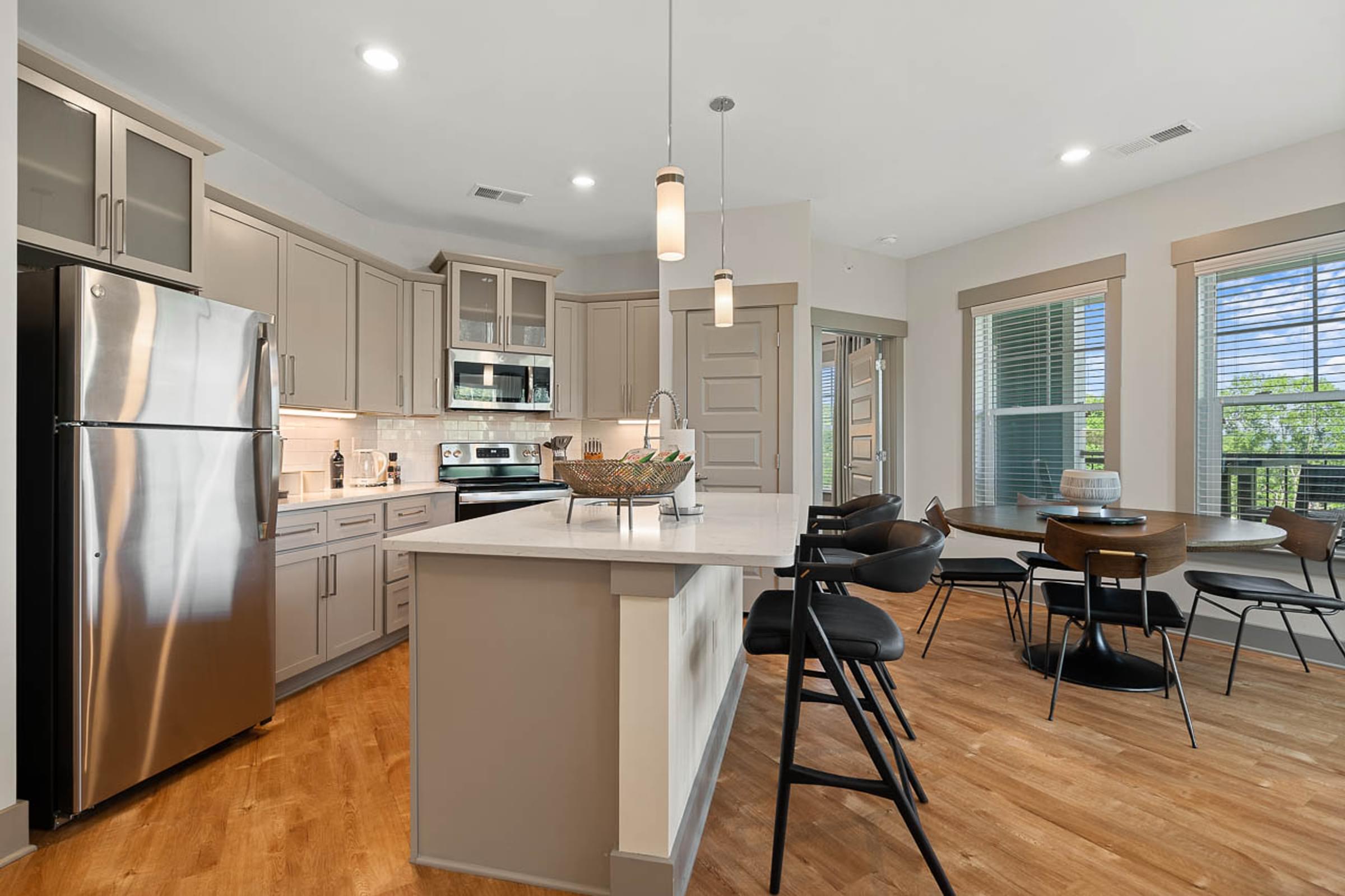 a kitchen with a center island and a stainless steel refrigerator