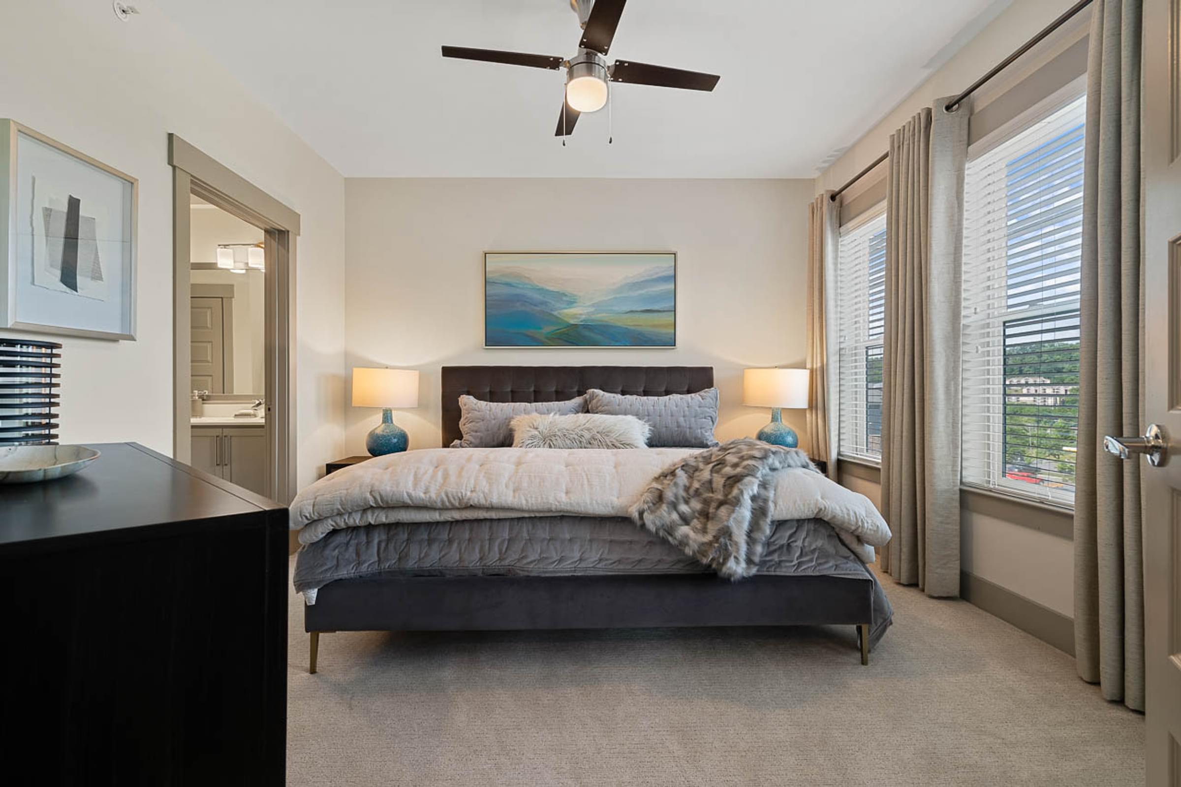Spacious Bedroom with Large Windows and Ceiling Fan