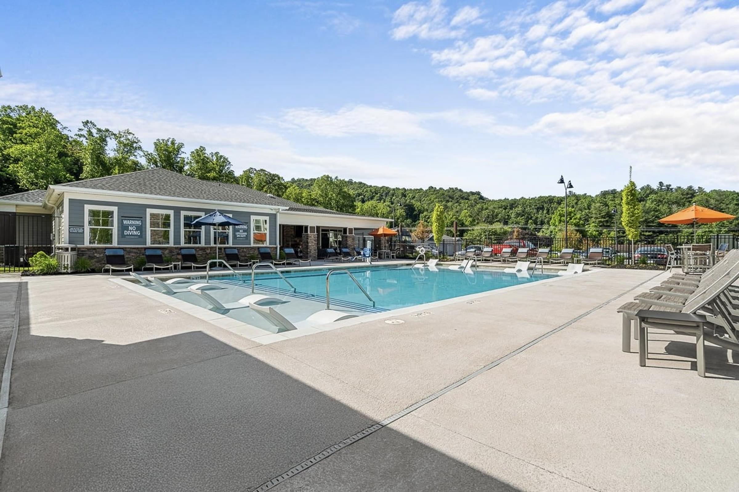 A large outdoor swimming pool with a building in the background.