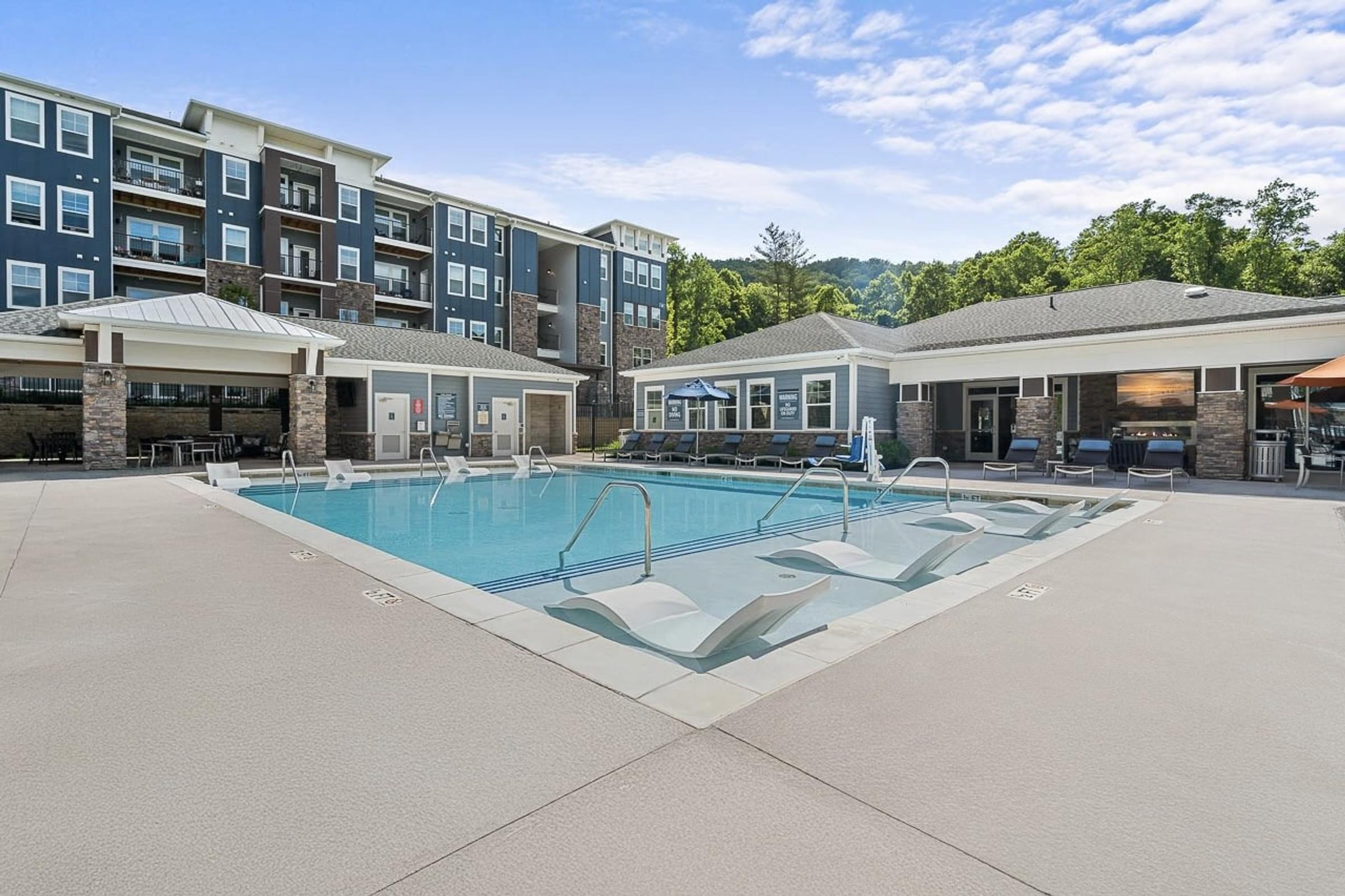 Resort Style Swimming Pool with Water Lounger Chairs