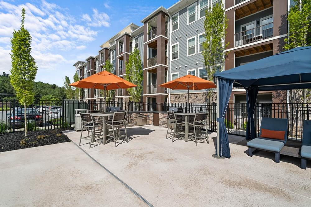 our apartments have a patio with tables and chairs and umbrellas