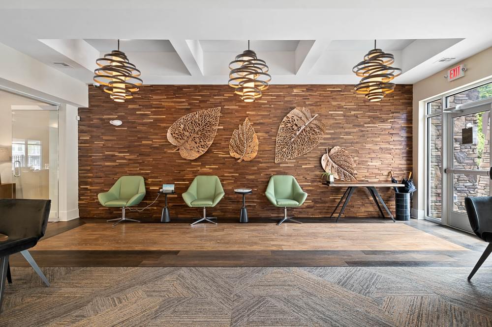 a lobby with chairs and a wall with feathers on it