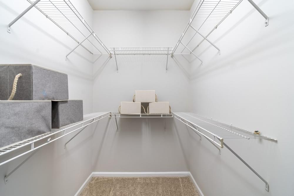 a white room with a white couch on a metal rack and a white chair in the corner