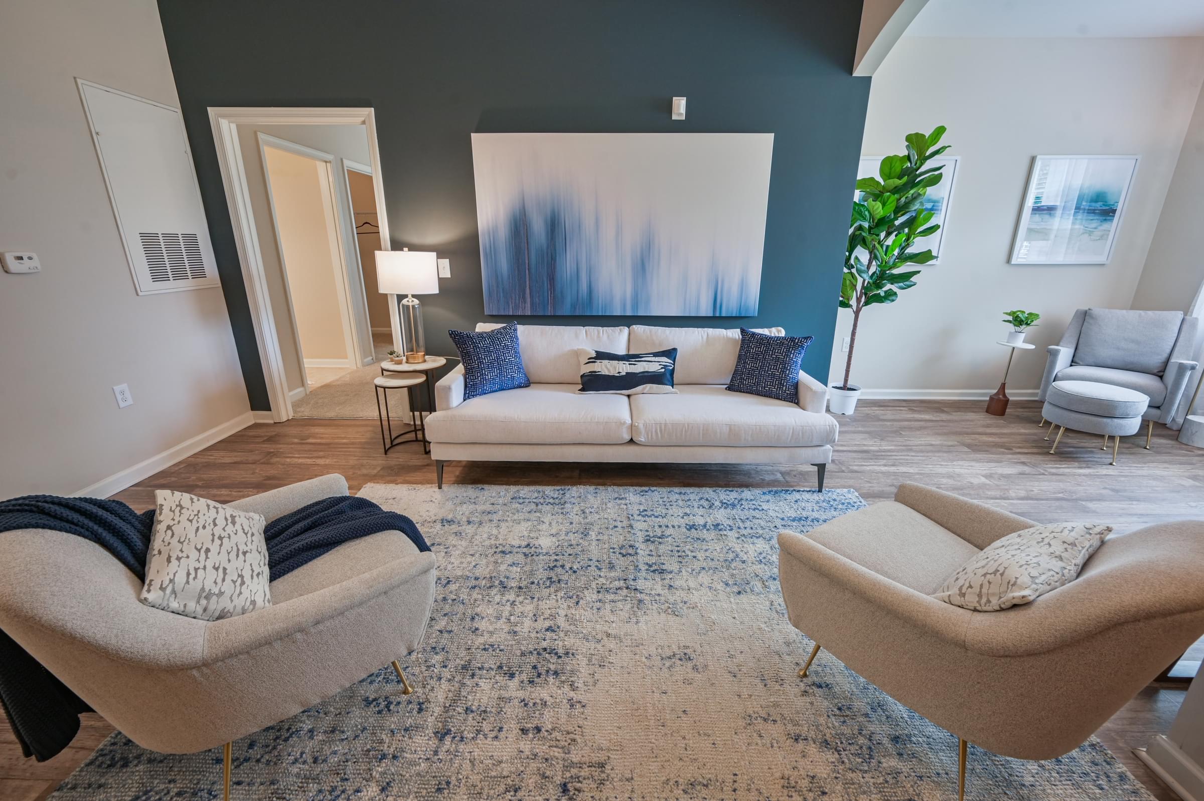 a living room with a couch and chairs and a rug