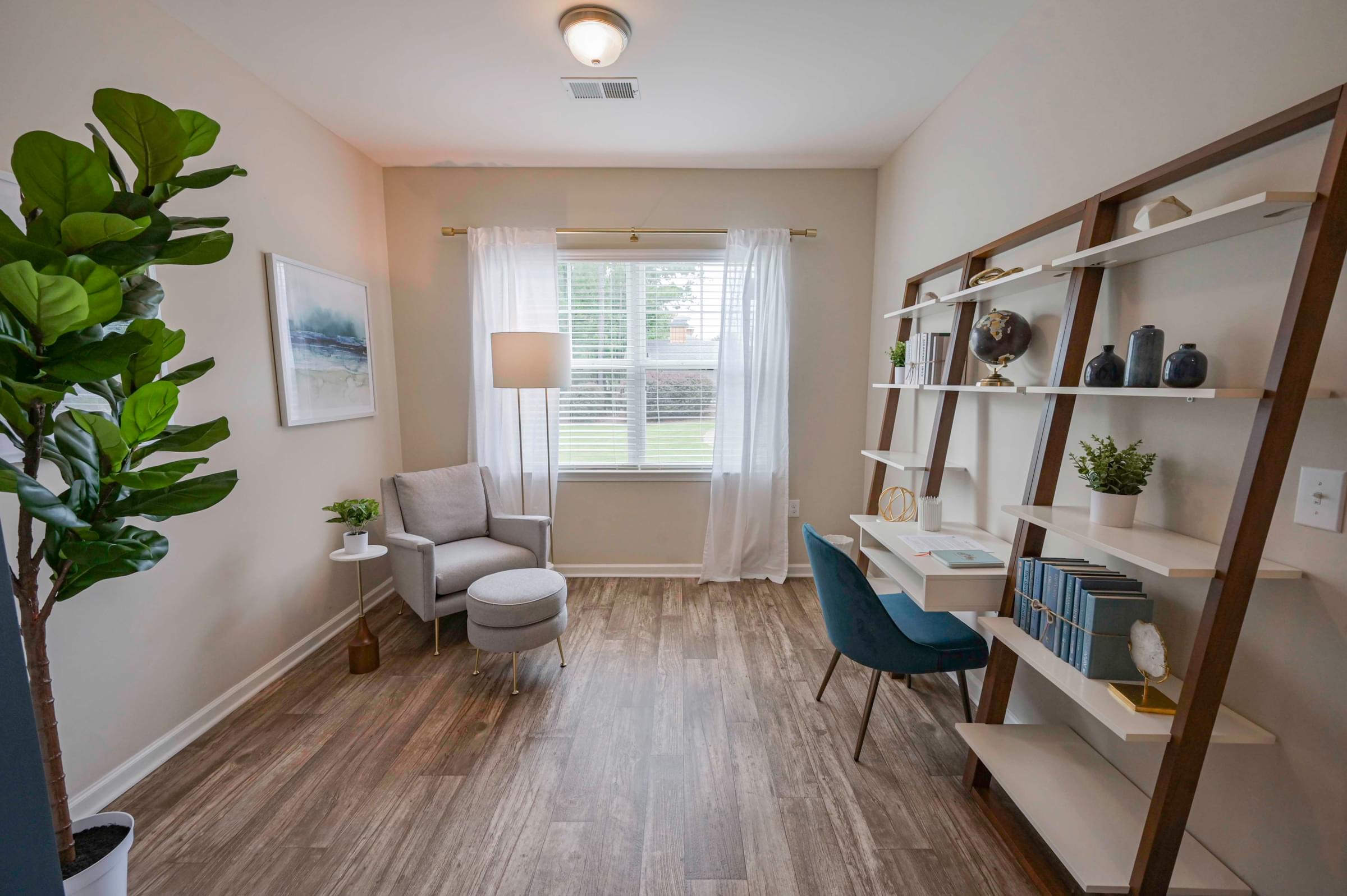 a home office with a desk and a chair and a window