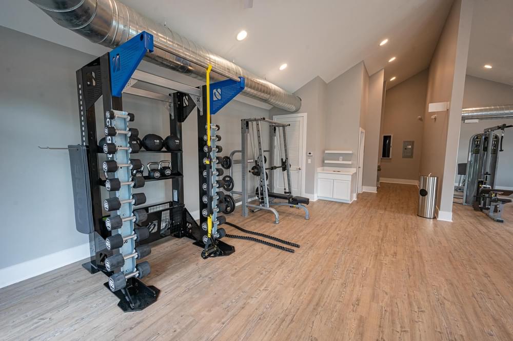 a home gym with weights and equipment on a wooden floor