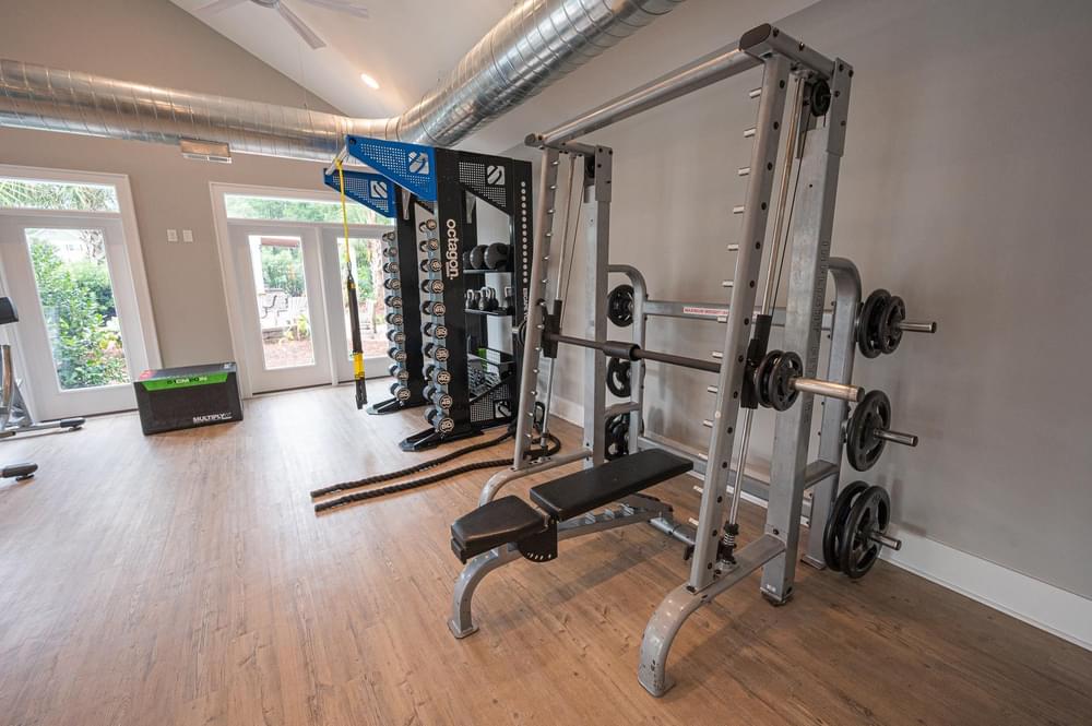 a home gym with weights on the wall and a wood floor