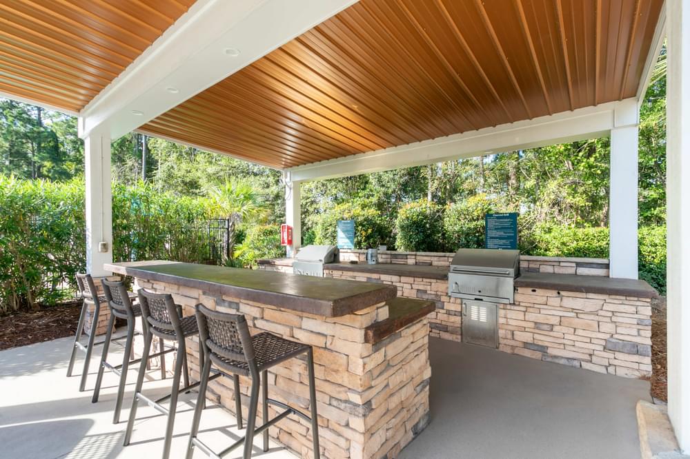a covered patio with a bar and a grill