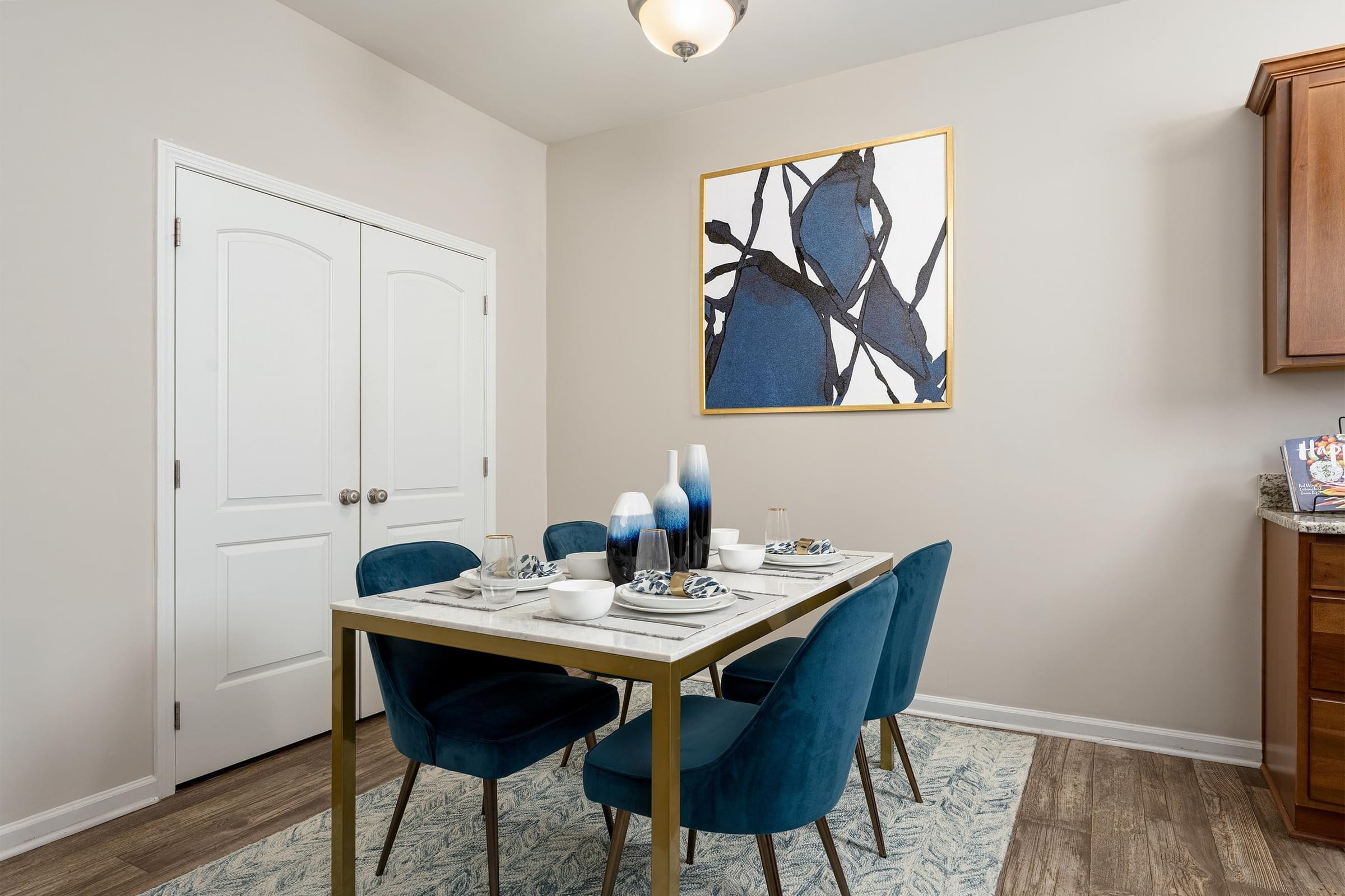 A dining room with a white table and blue chairs.