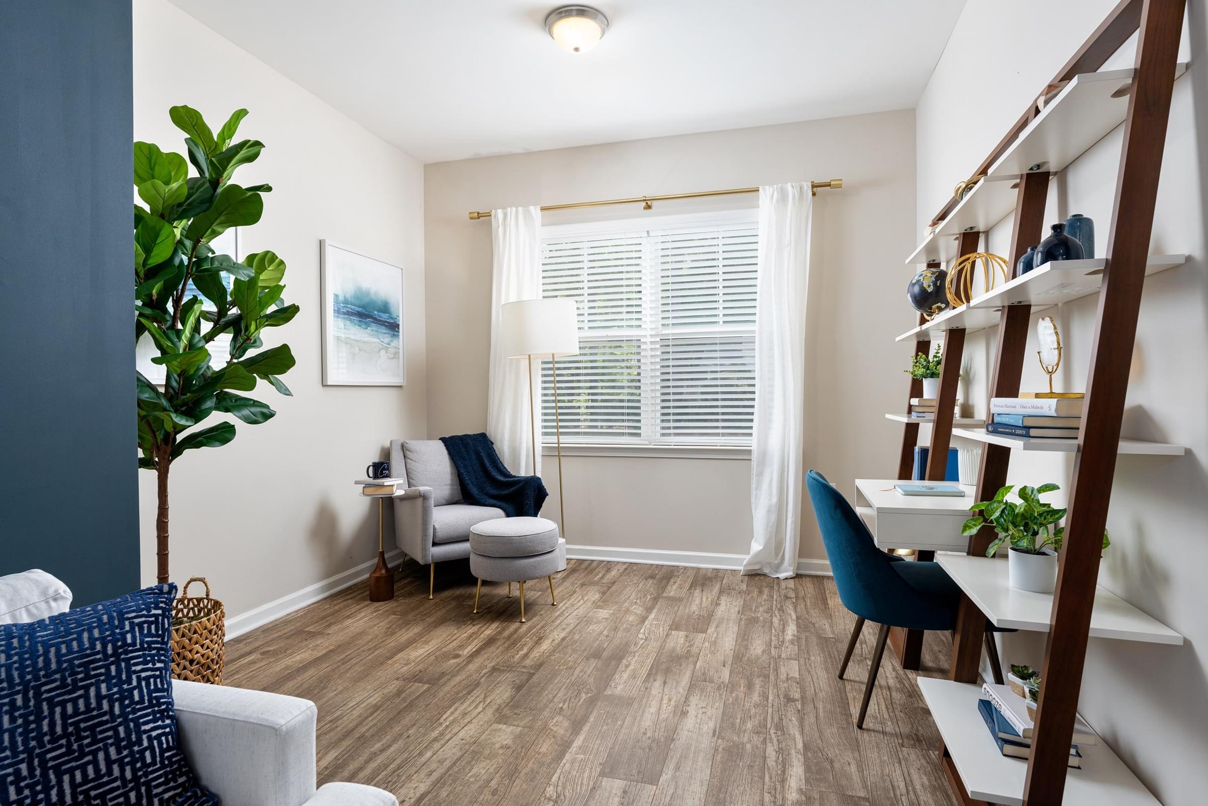 A living room with a blue chair and a white couch.