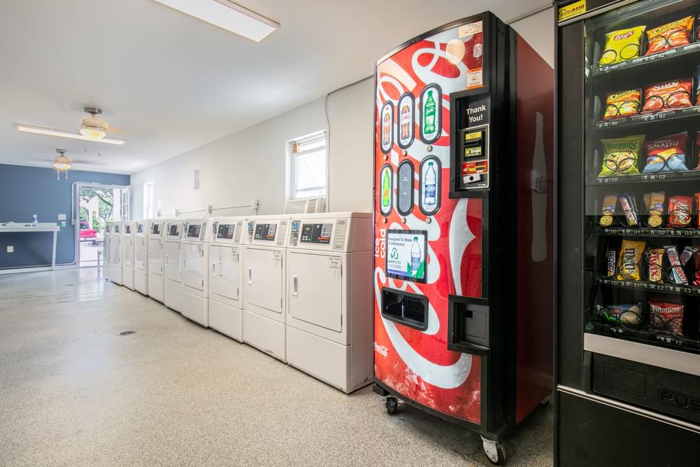 the vending machines in the center of the building are in front of the washes
