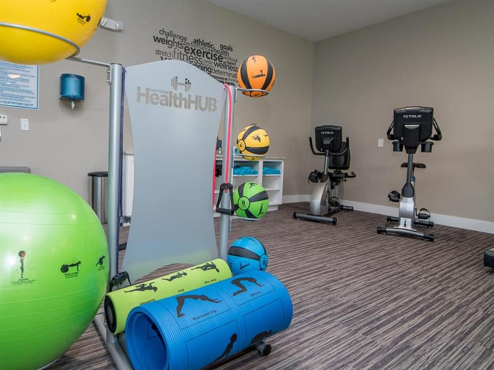 a gym with weights and balls on the floor and a sign