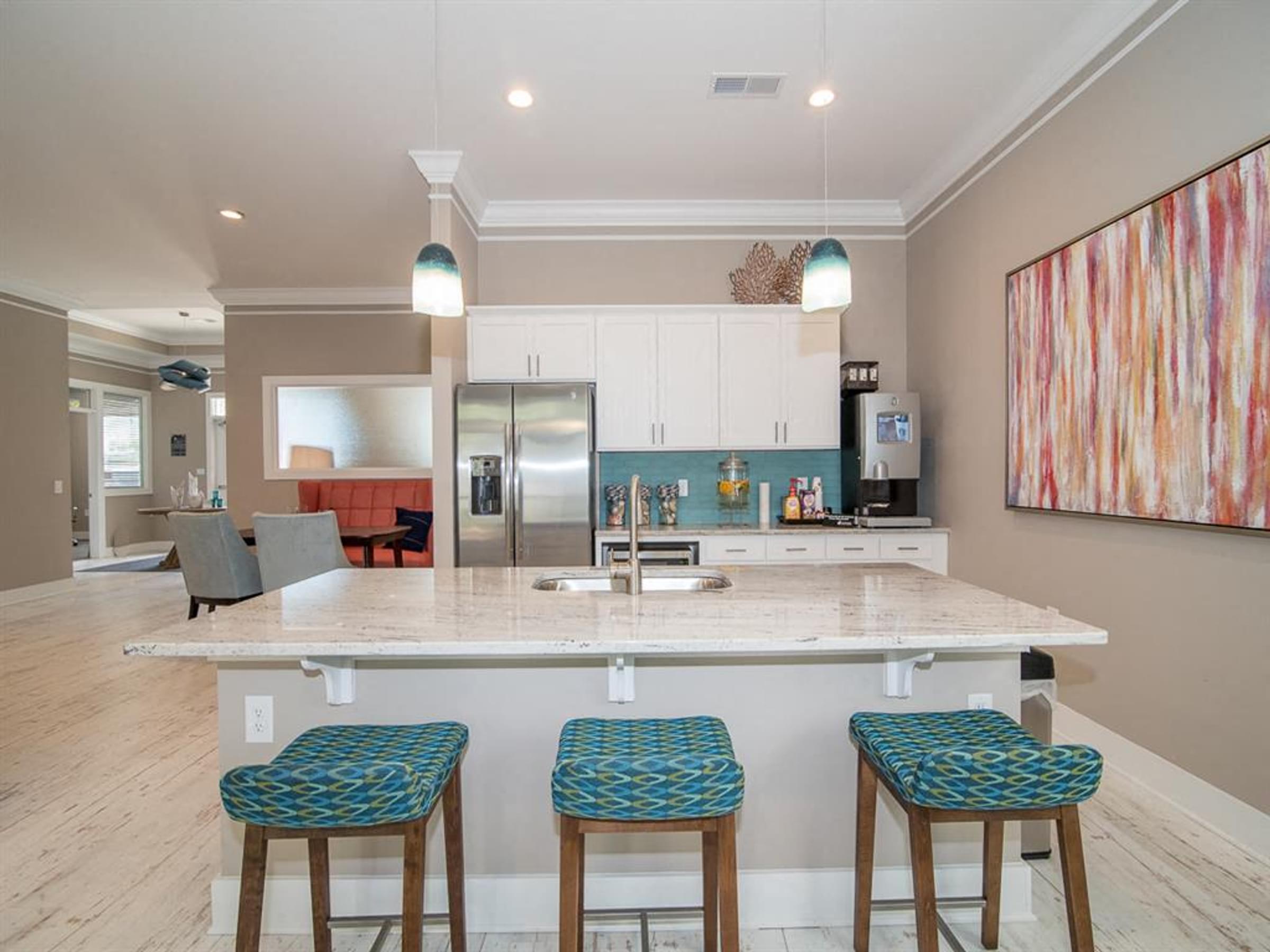 a kitchen with a bar and three stools