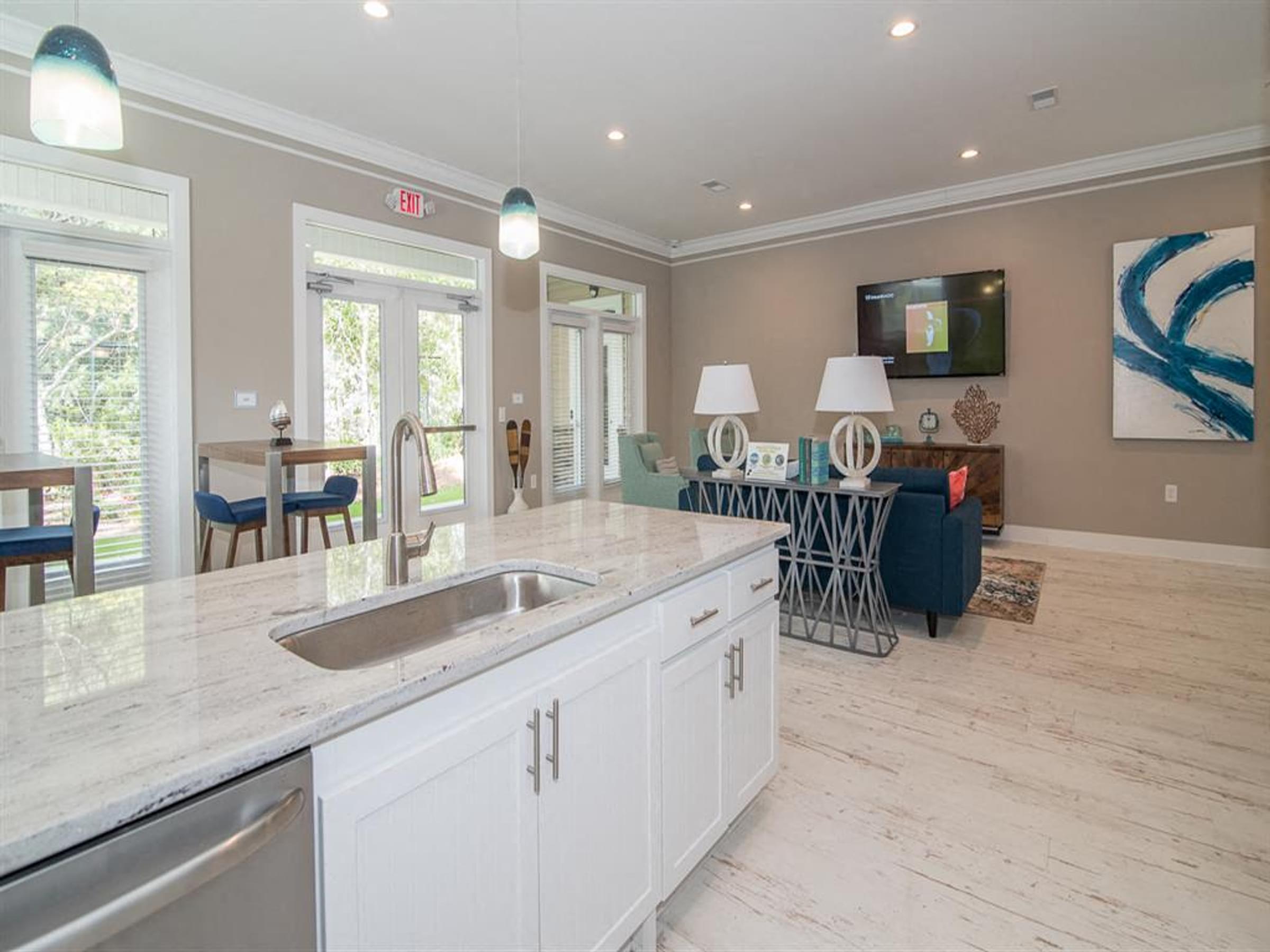 a white kitchen with a sink and a living room