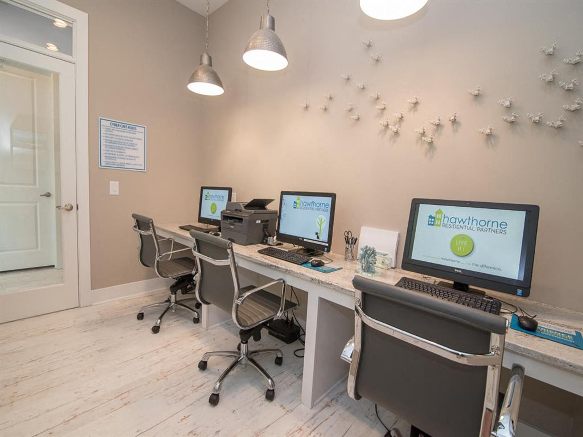 a room with three desks with computers on it