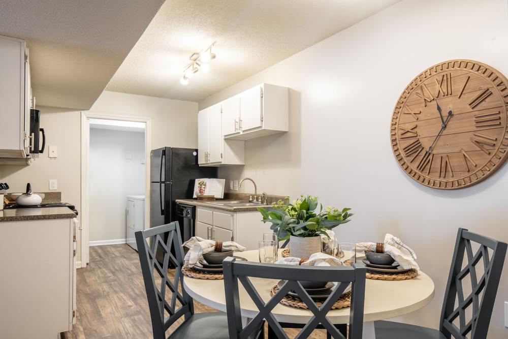 our apartments offer a dining room table and a kitchen with a large clock