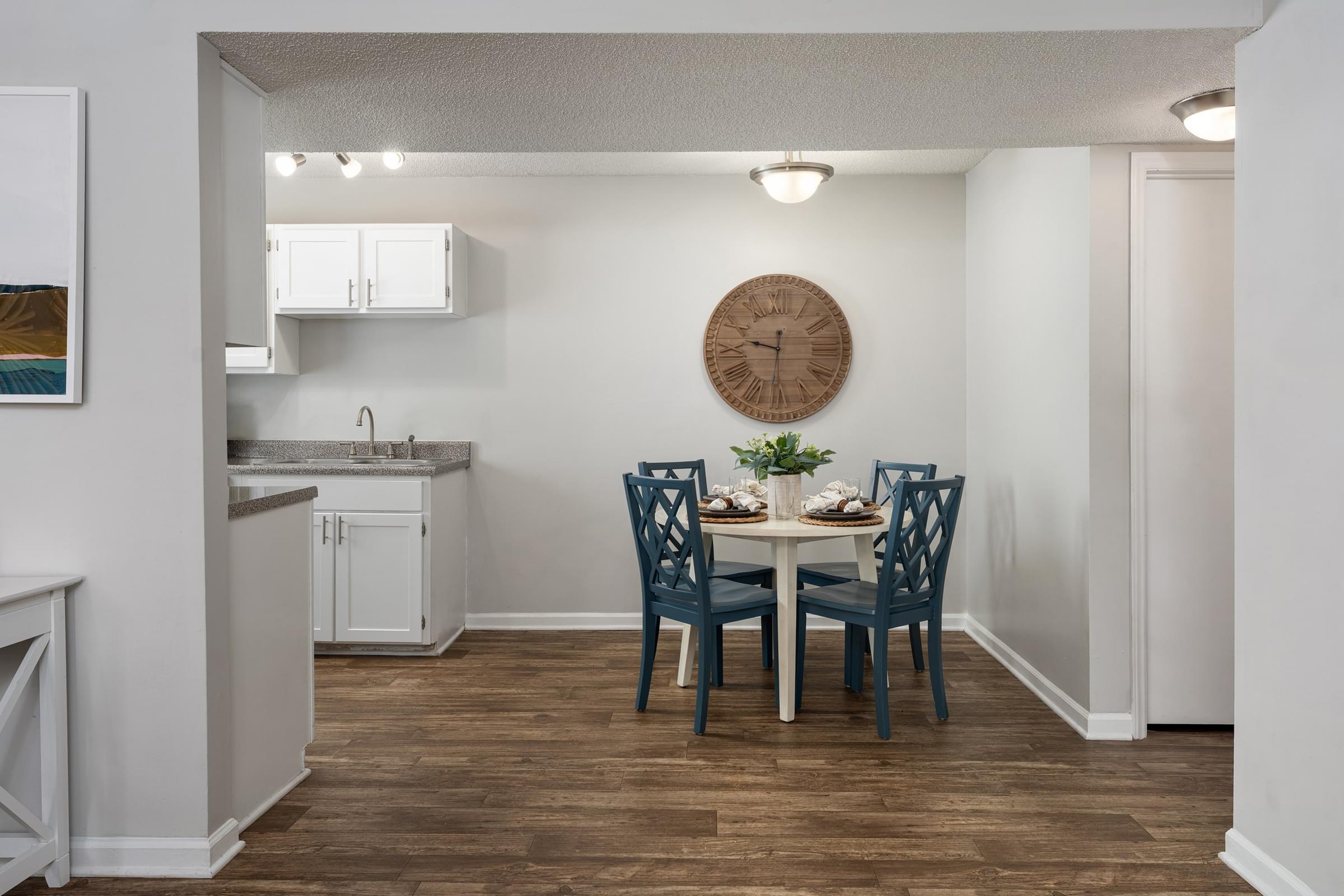A kitchen with a dining table and chairs.