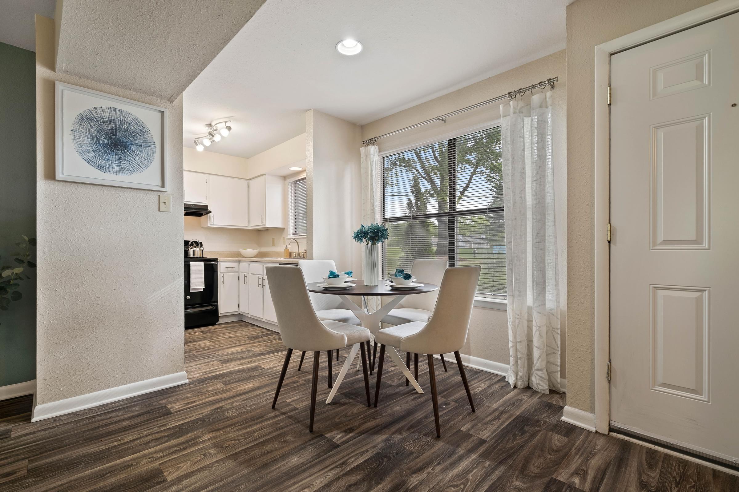 A dining room with a table and chairs and a kitchen at Hawthorne at Oak Ridge in Greensboro, NC
