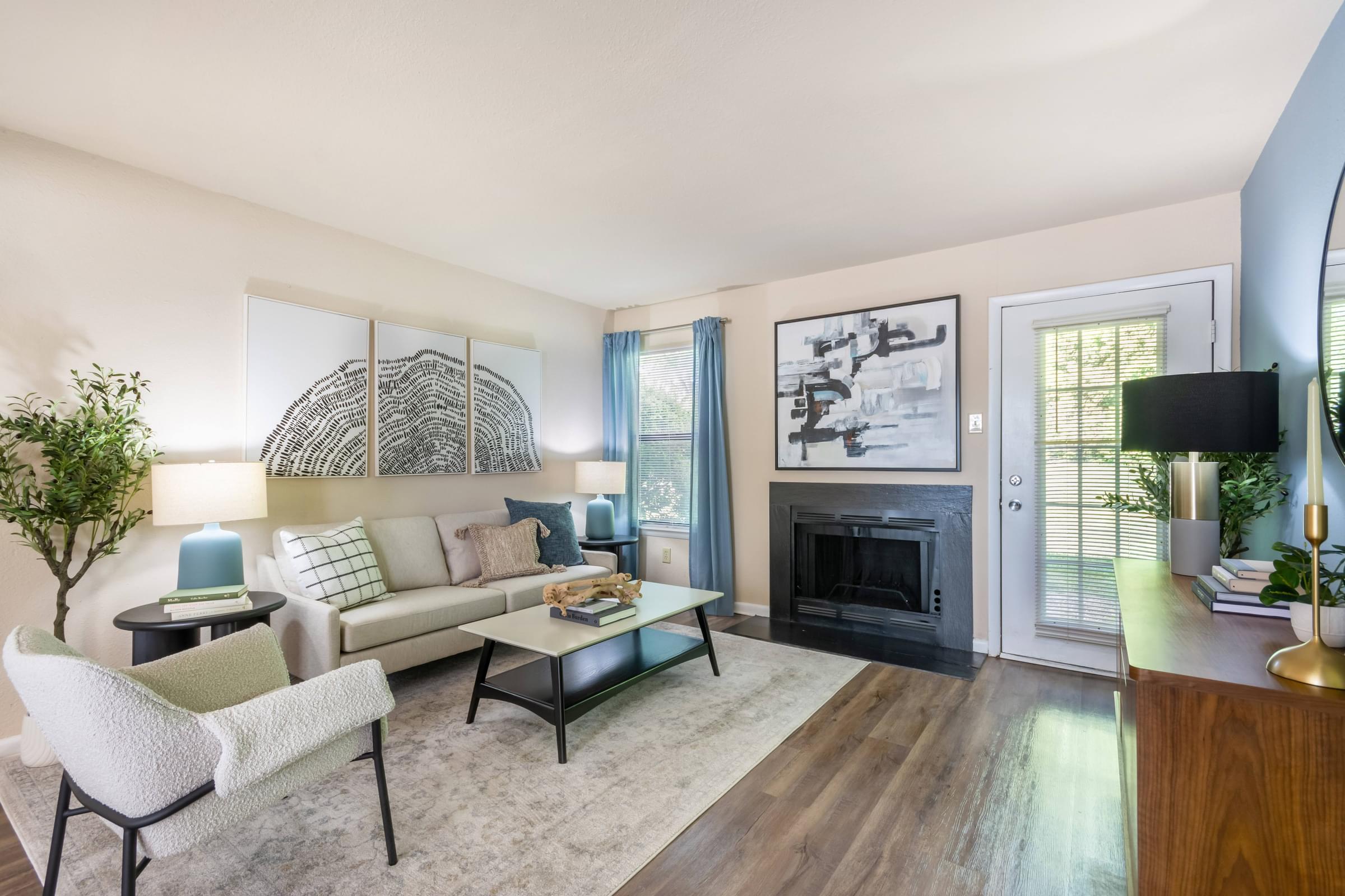 A living room with a fireplace and a couch at Hawthorne at Oak Ridge in Greensboro, NC.