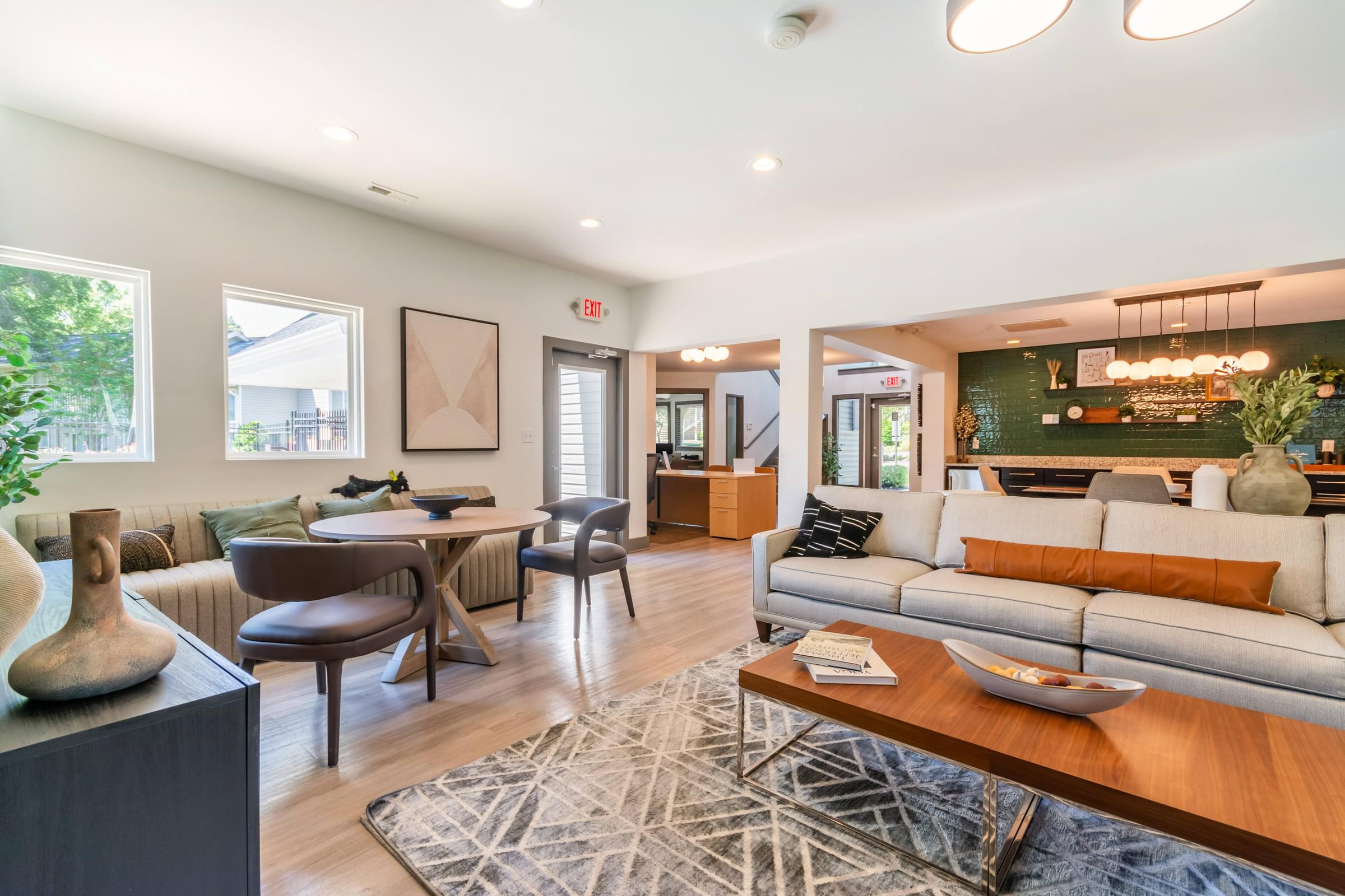 A clubhouse with a white couch and a wooden coffee table at Hawthorne at Oak Ridge in Greensboro, NC.