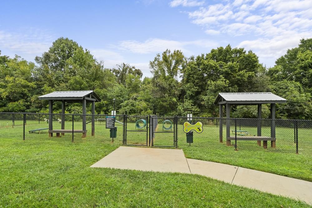 a park with a playground and two picnic shelters
