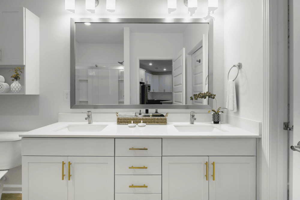 a white bathroom with two sinks and a large mirror