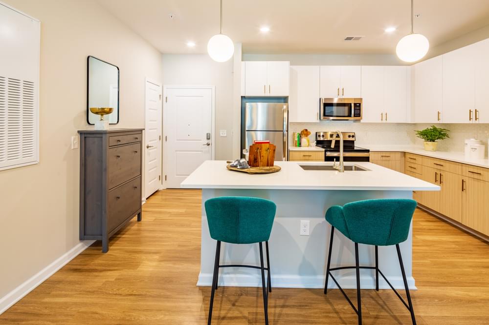 a kitchen with a white counter top and blue chairs
