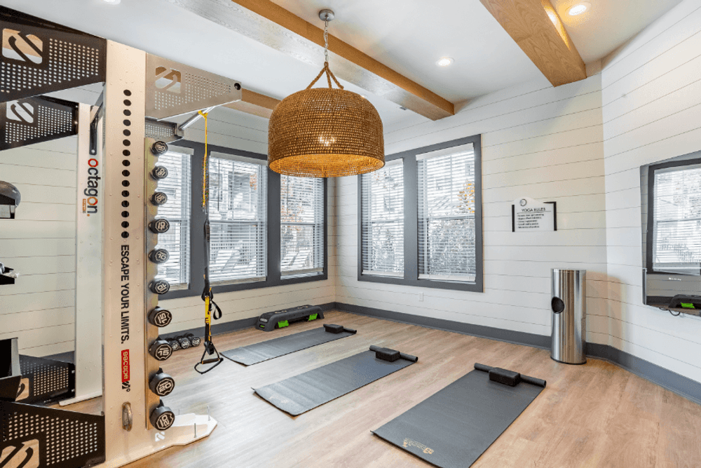 a yoga room with yoga mats on the wall and a hanging light