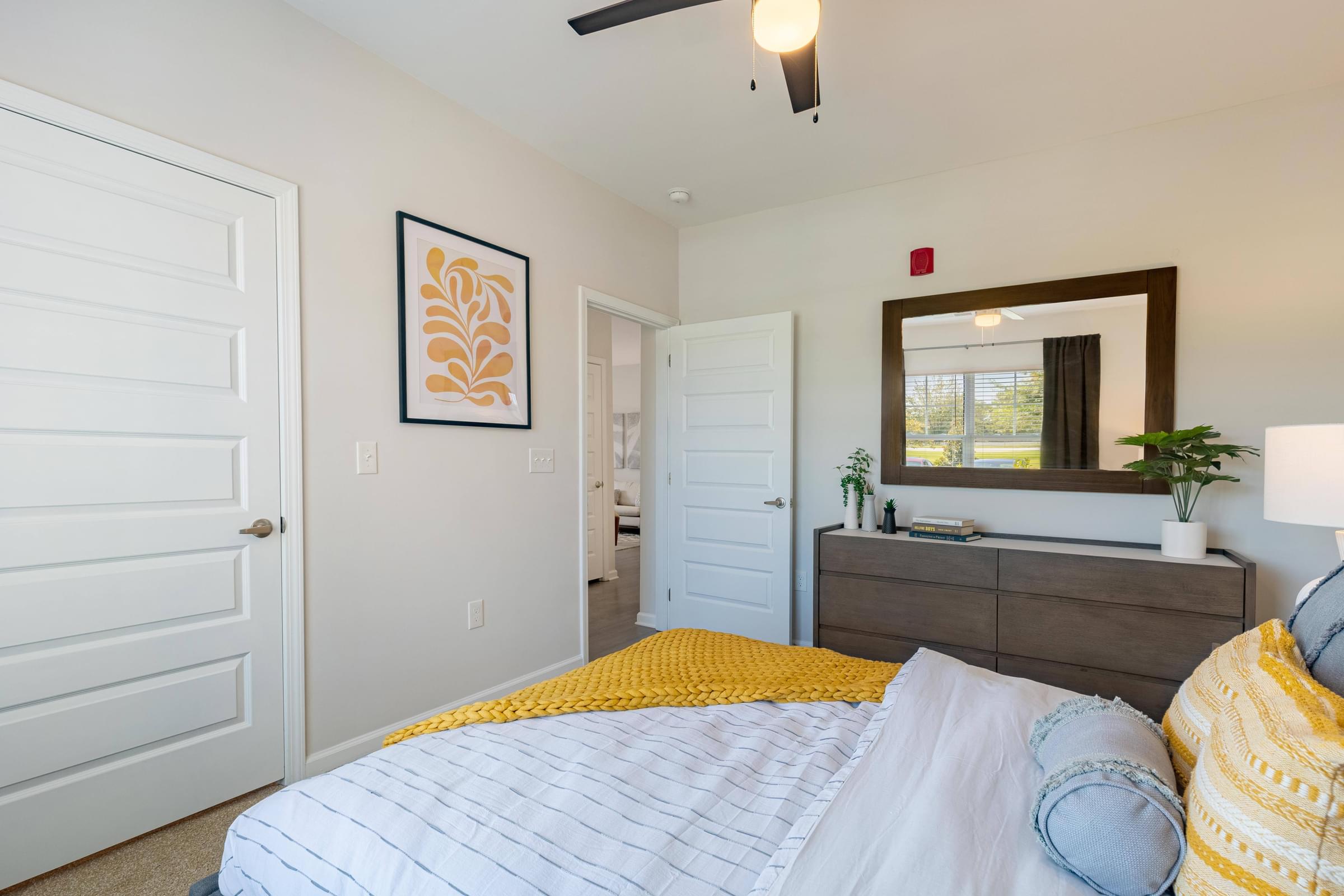 a bedroom with a bed and a dresser and a mirror