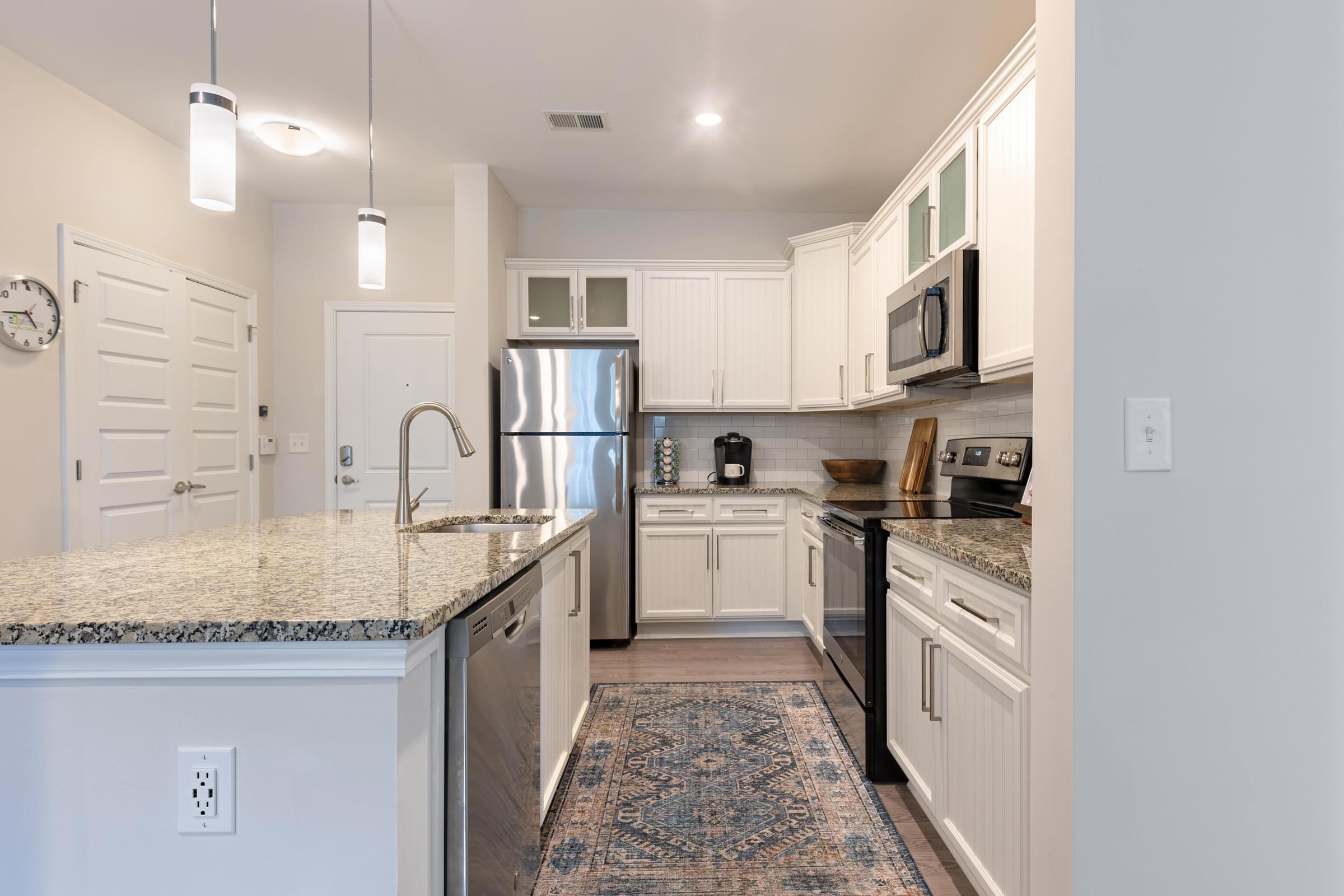 Kitchen with Custom White Cabinetry and Pendant Lighting