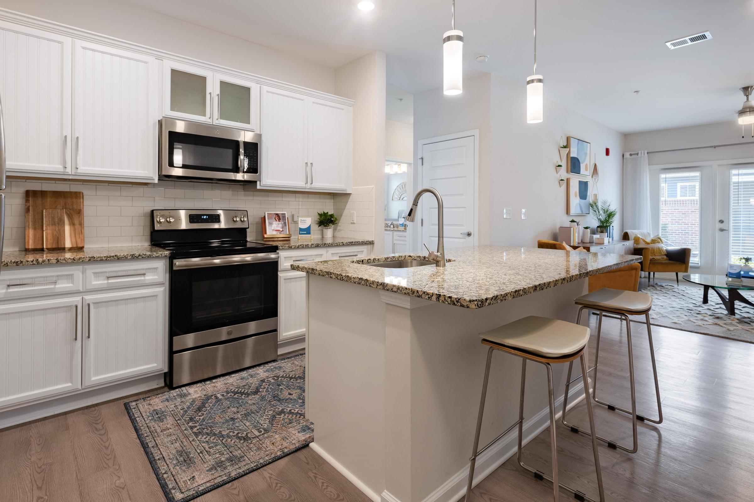 an open kitchen with a large island with granite counter tops