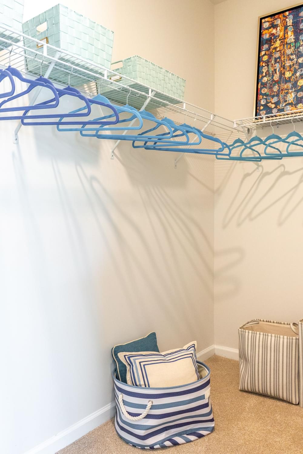 a closet with a white wall and a blue wire shelf on top of the wall