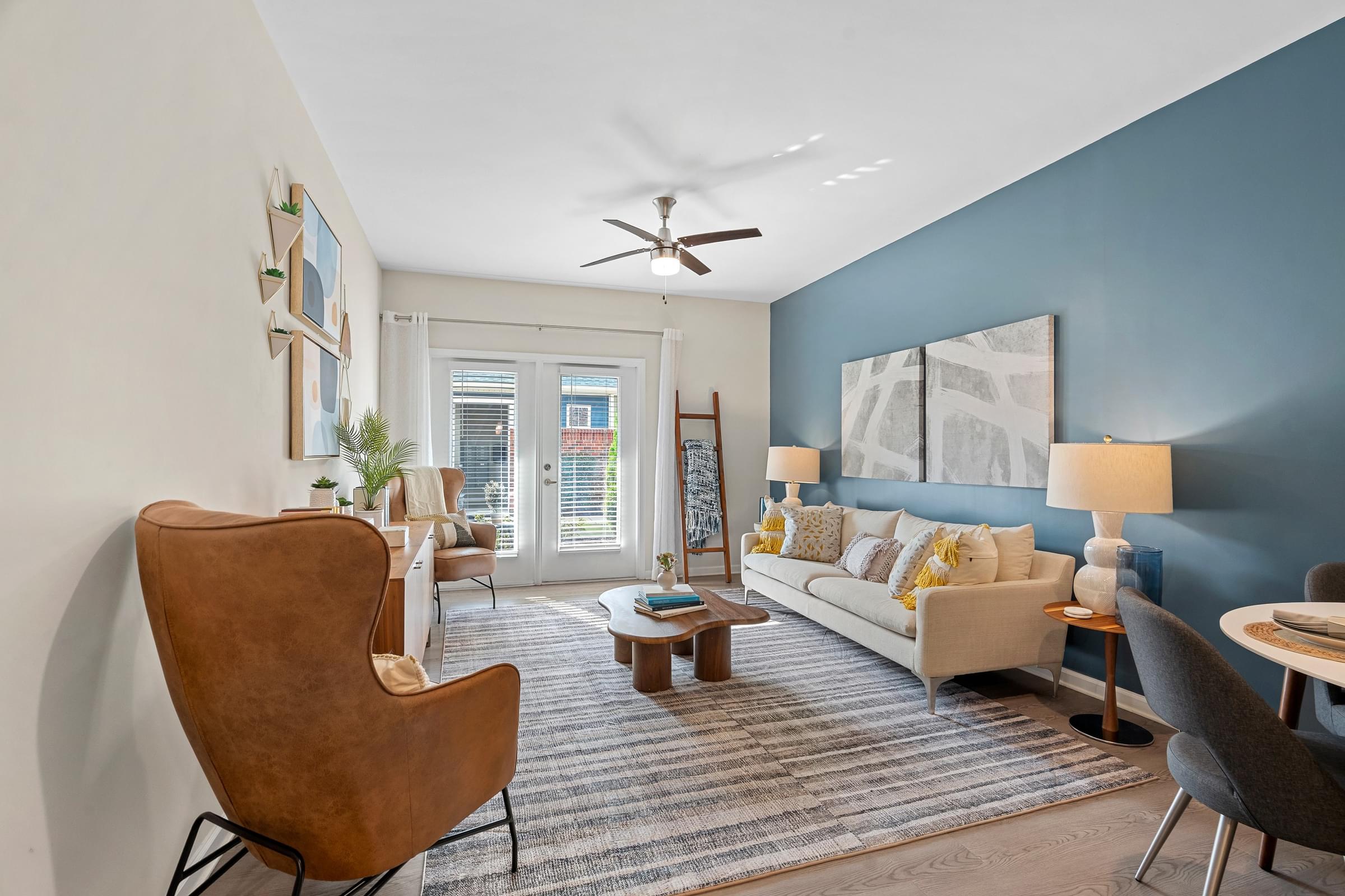 A living room with a brown chair and a couch with pillows.