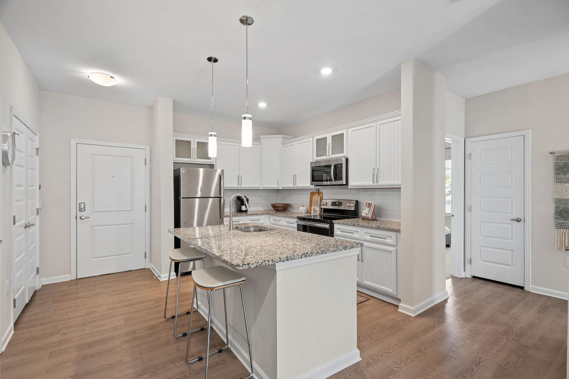 A kitchen with a granite countertop and stainless steel appliances.