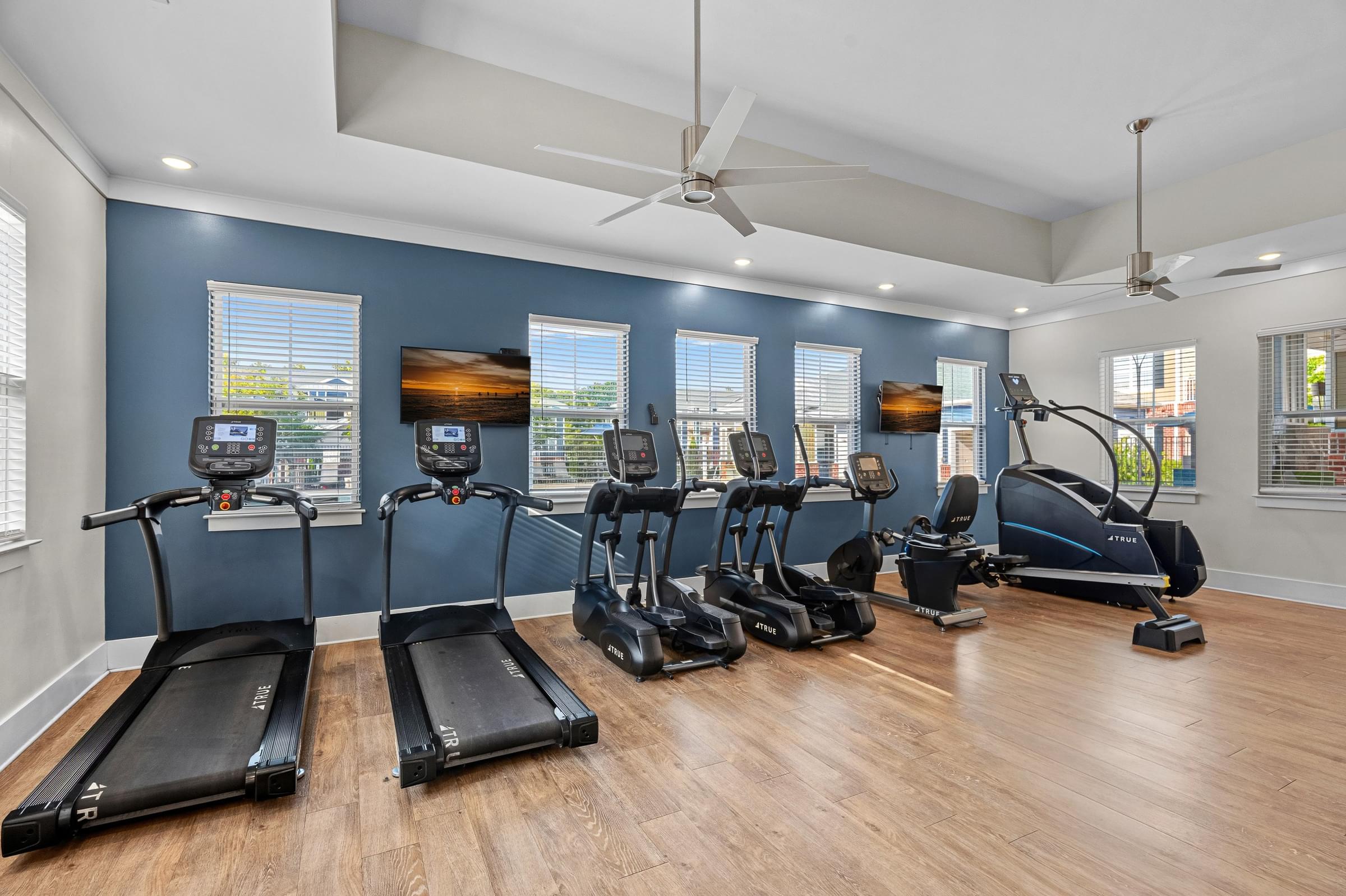 A spacious room with treadmills and elliptical machines.
