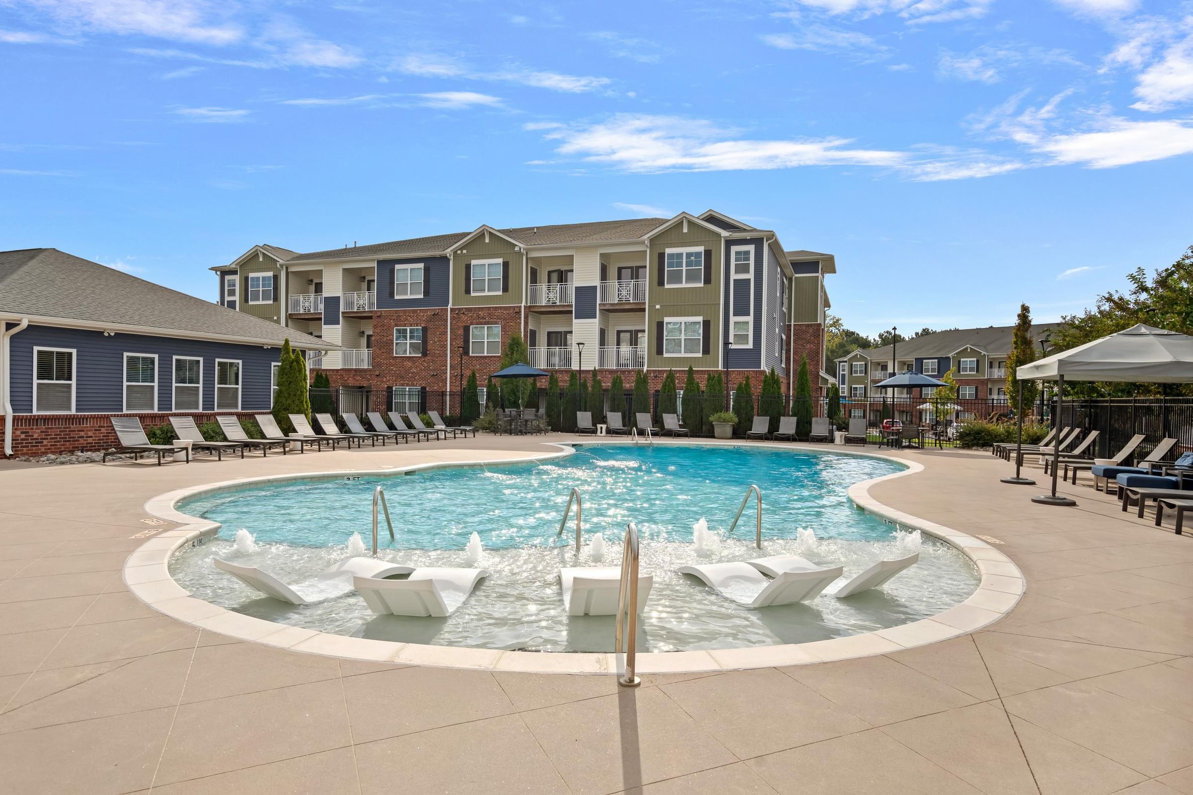A large swimming pool with a fountain in the middle of a residential area.