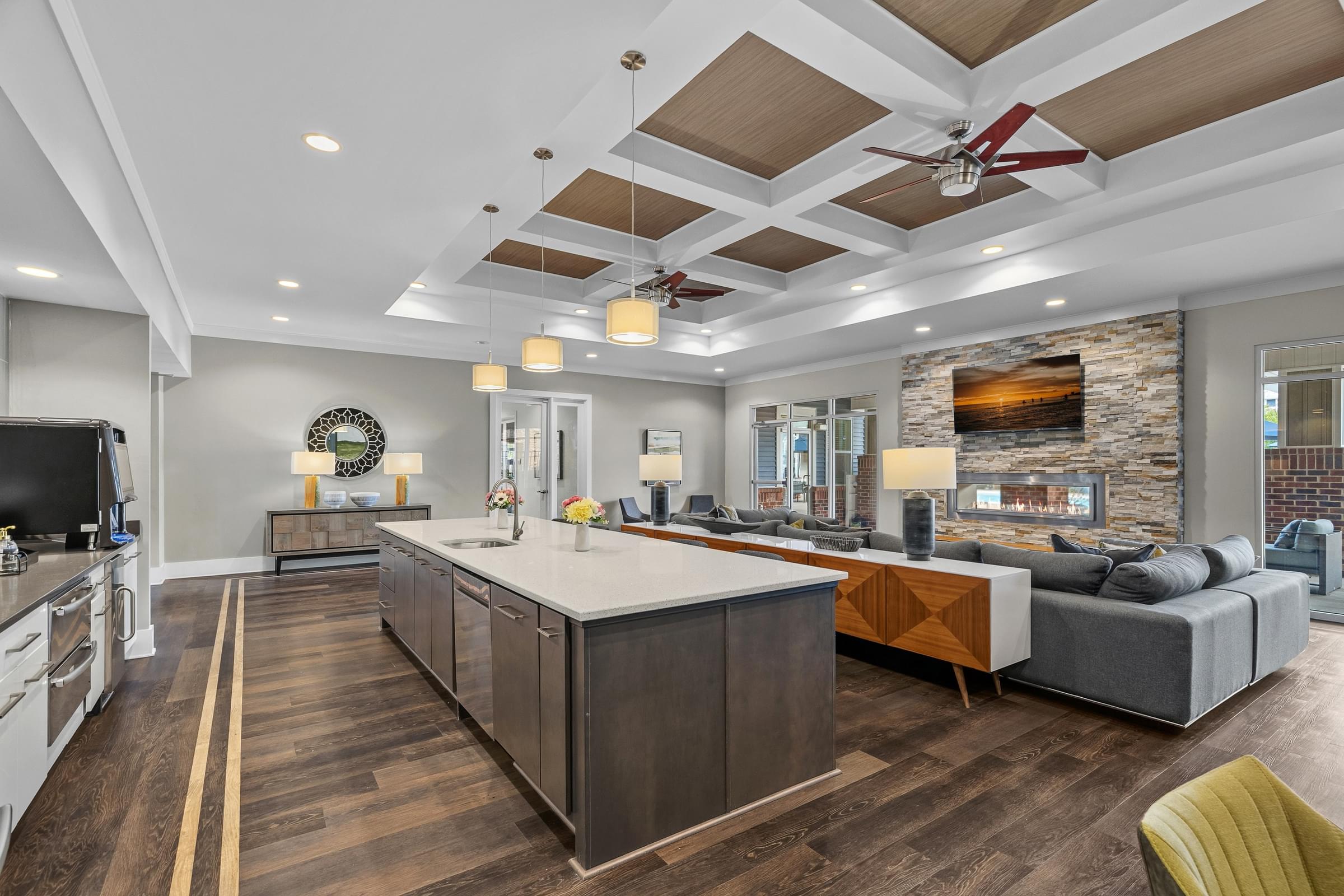 A modern kitchen with a large island and a fireplace in the background.
