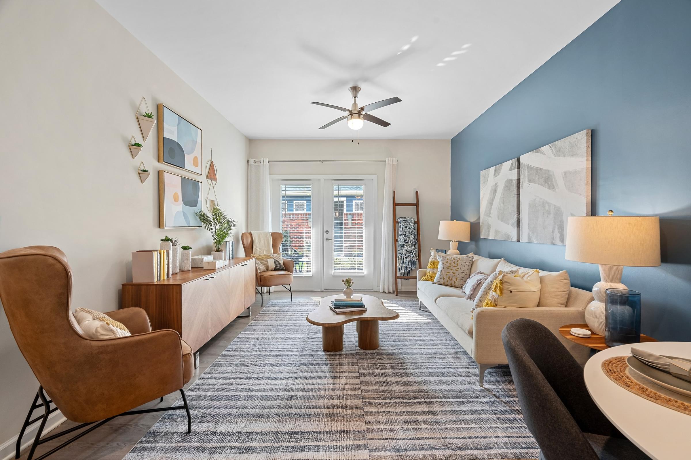 A living room with a brown chair and a white couch.