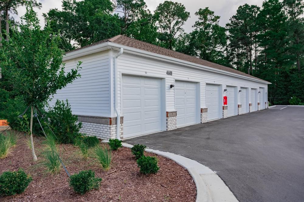 a white garage with white doors and a driveway