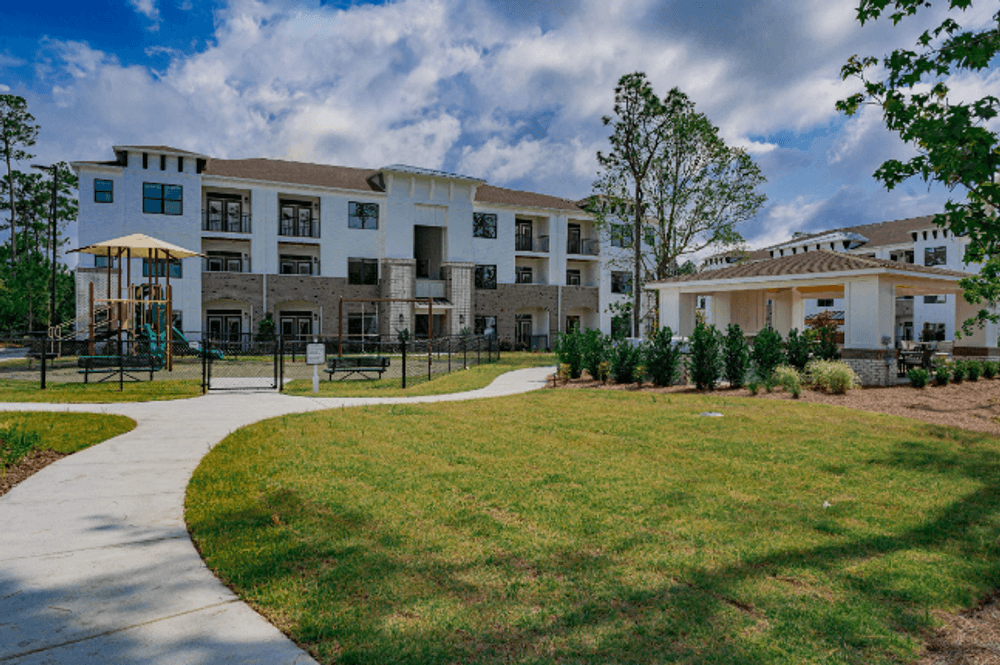 the preserve at cardinal heights apartments exterior view of the building with green grass and trees