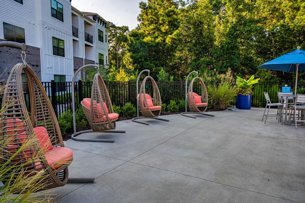 our apartments have a large patio with chairs and an umbrella