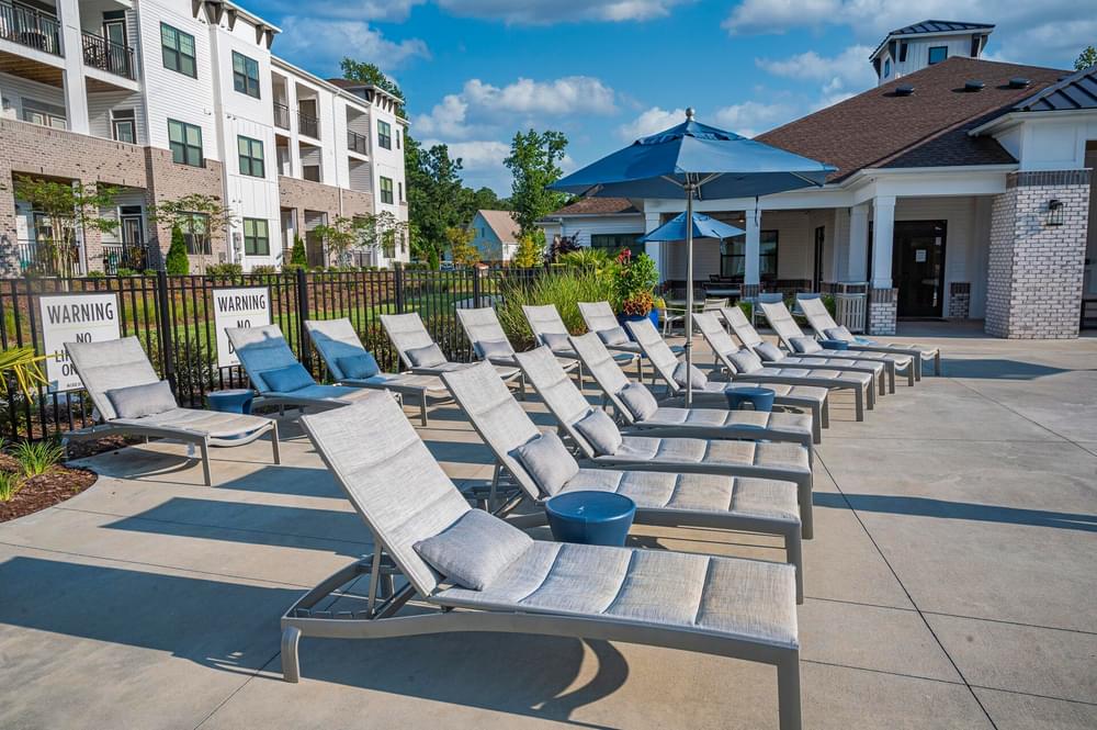 a row of lounge chairs in front of an apartment building