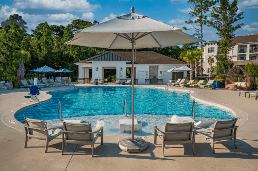 a swimming pool with chairs and an umbrella