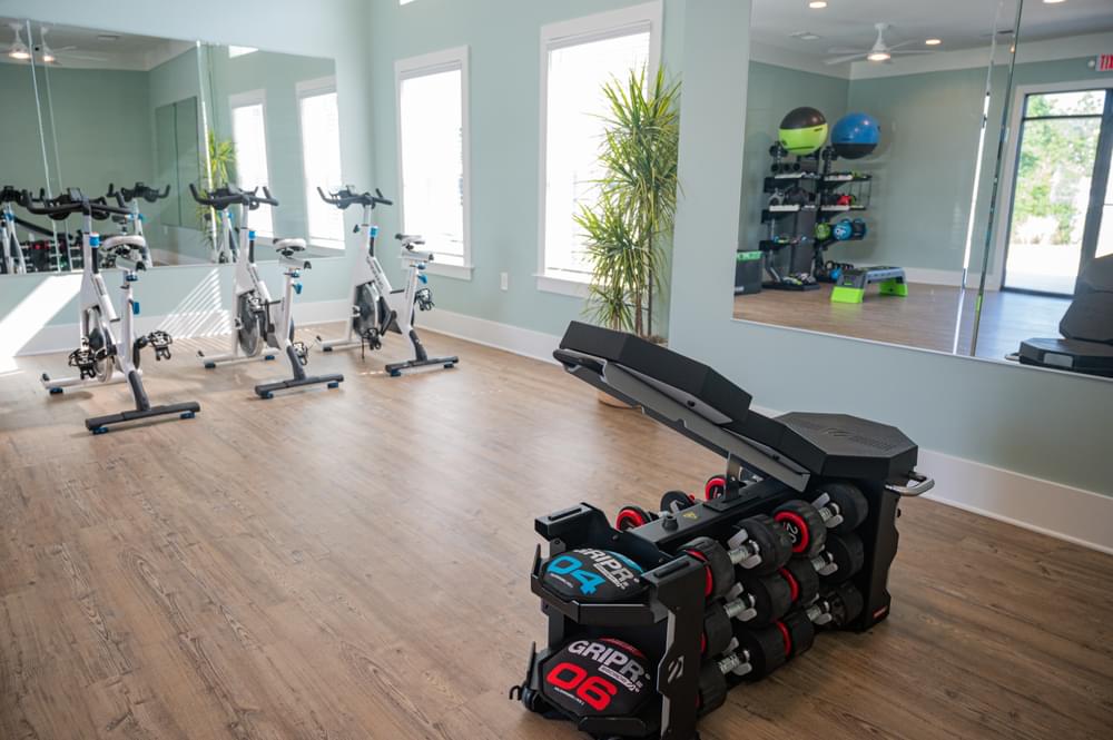 a home gym with weights and exercise equipment on a wooden floor
