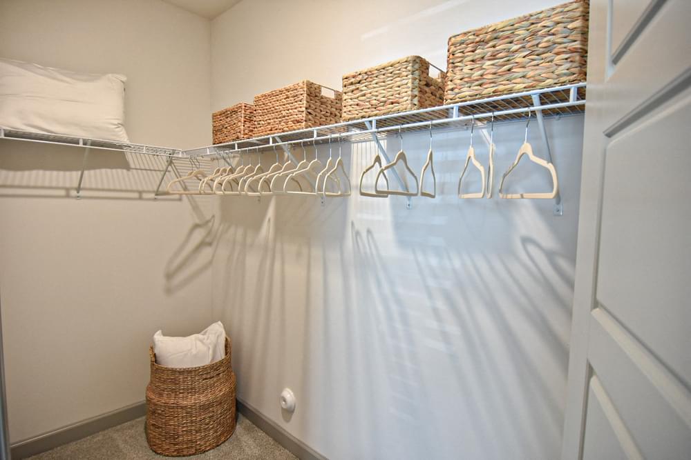 Walk in closet with wicker baskets and felt hangers Hawthorne at Smith Creek