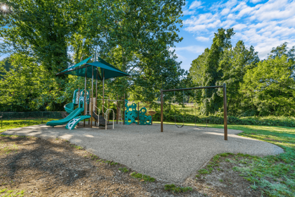 a playground with a swing set and other toys in a park